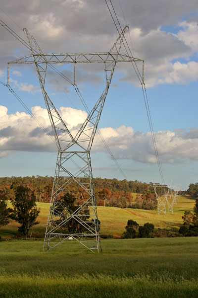 high voltage towers marching over the hill