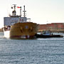 tugboats turning a tanker