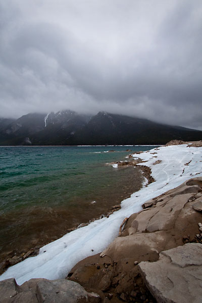 ice lines the banks of Lake Minnewanka