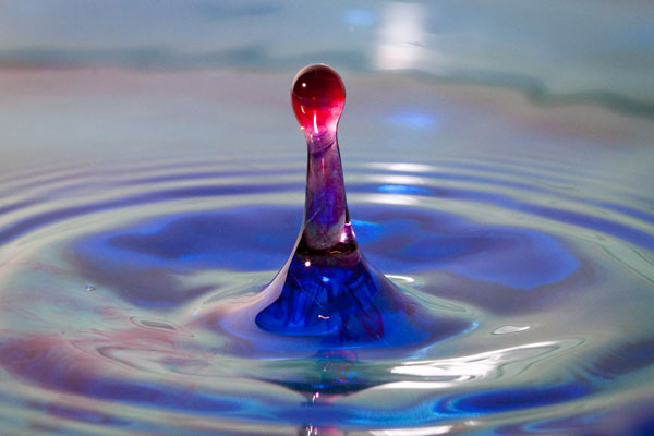 red water dropping into blue water