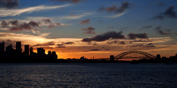 sun setting behind Sydney city