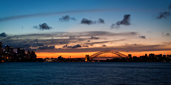 sunset behind the Sydney Opera House and Sydney Harbour Bridge