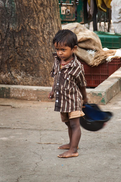 a young boy plays with a motorbike helmet