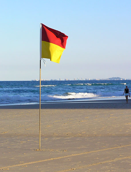 Lonely lifeguard flag on the beach